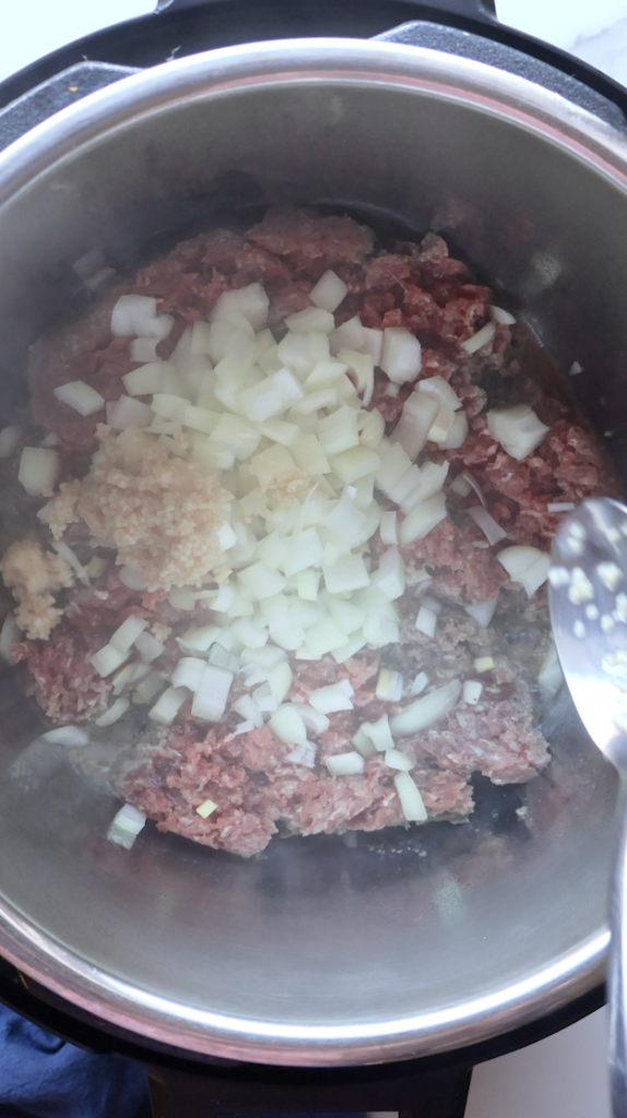 onions being sautéed with beef and garlic